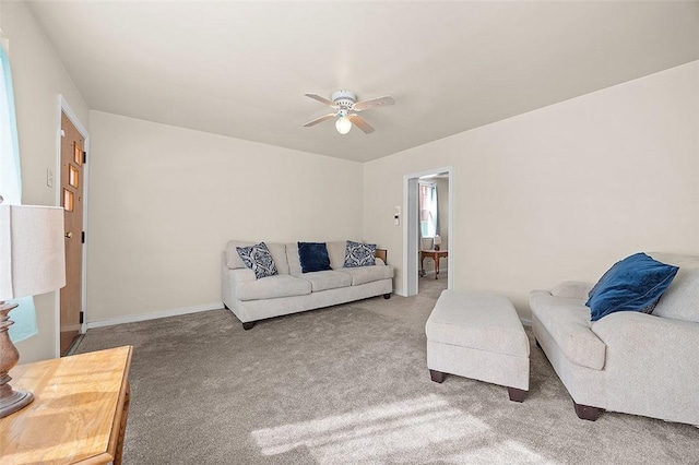 living area with a ceiling fan, carpet, and baseboards