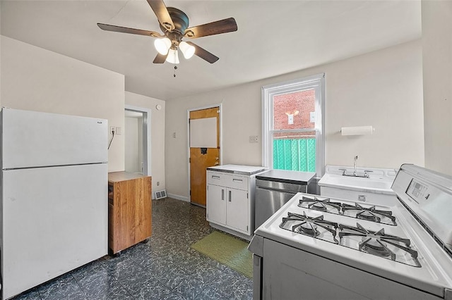 kitchen featuring white appliances, ceiling fan, dark flooring, light countertops, and white cabinetry