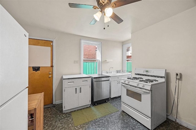 kitchen featuring white appliances, ceiling fan, light countertops, baseboards, and a sink