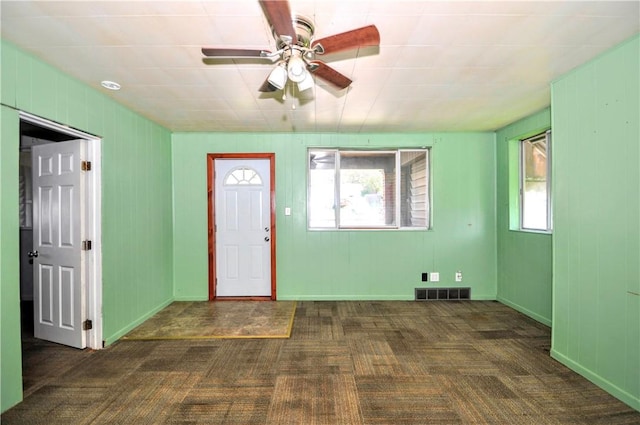 foyer entrance featuring carpet, visible vents, and ceiling fan