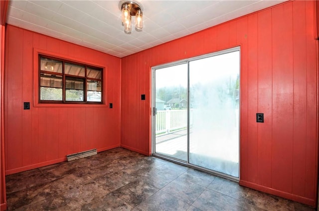 unfurnished room featuring visible vents and wood walls