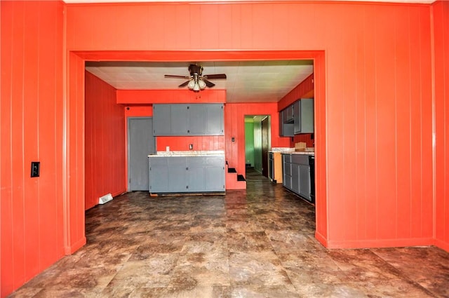interior space featuring wood walls and a ceiling fan