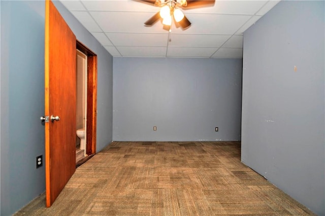 empty room featuring carpet floors, ceiling fan, and a paneled ceiling