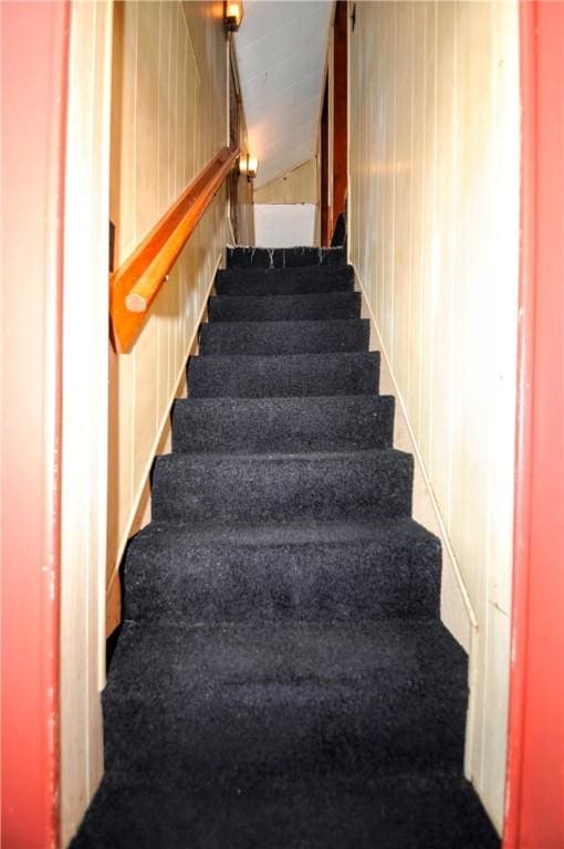 stairs featuring lofted ceiling and carpet