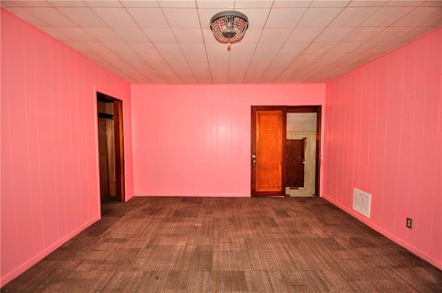 empty room with dark carpet and visible vents