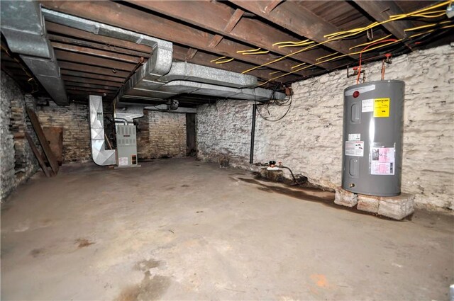 unfinished below grade area with heating unit and electric water heater