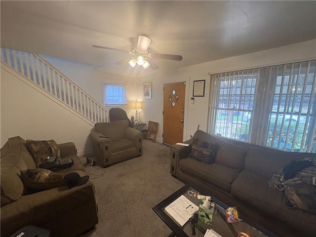 carpeted living room with stairway and a ceiling fan