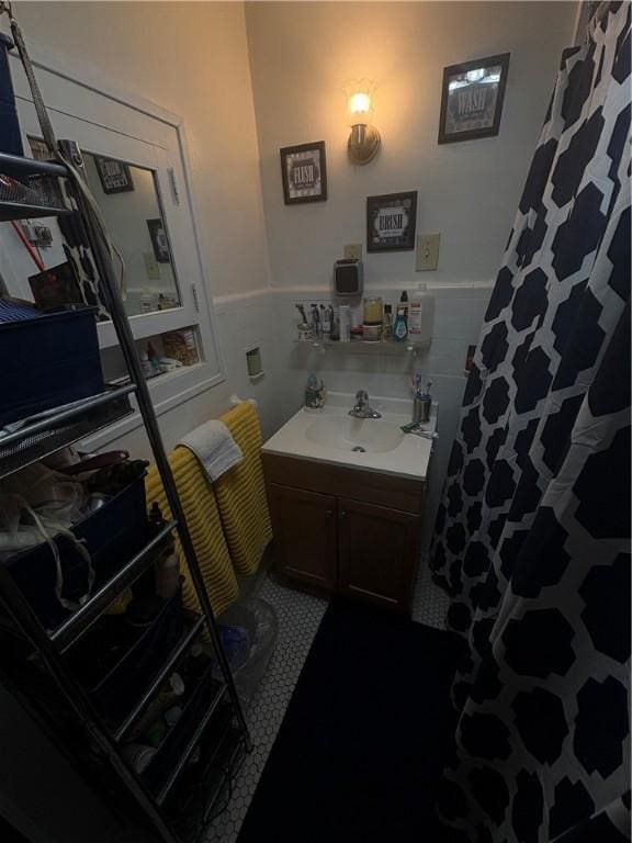 full bathroom with wainscoting, vanity, and a shower with shower curtain
