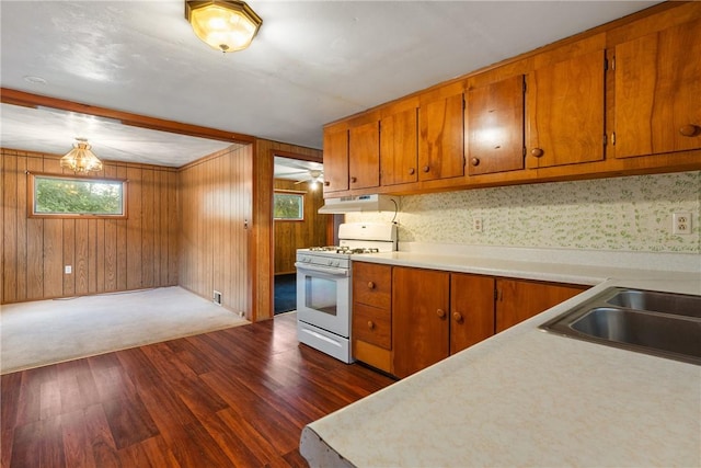 kitchen featuring light countertops, dark wood finished floors, white gas range oven, and brown cabinets