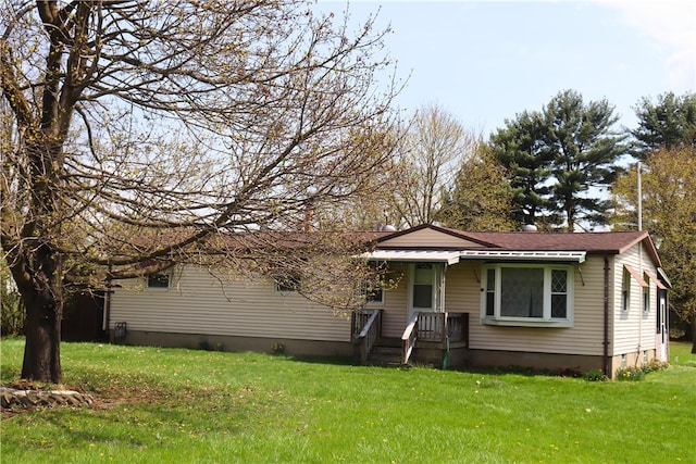 ranch-style house featuring a shingled roof and a front lawn