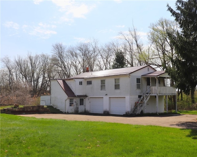 view of front of property featuring a garage, a front yard, driveway, and stairs