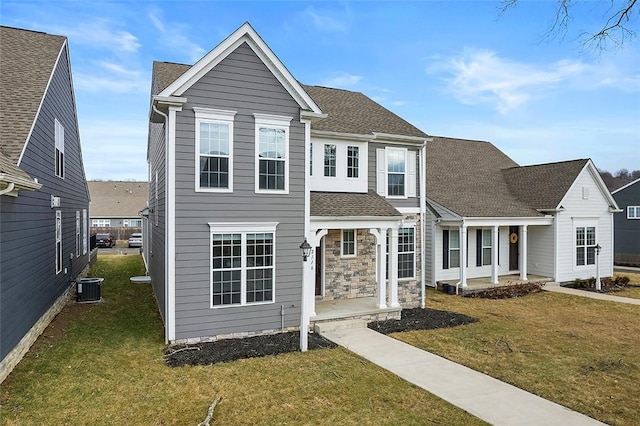 view of front of home with covered porch, stone siding, cooling unit, and a front yard