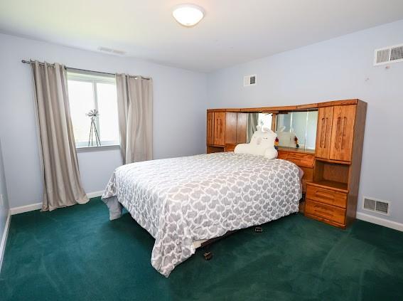 bedroom featuring dark carpet and baseboards