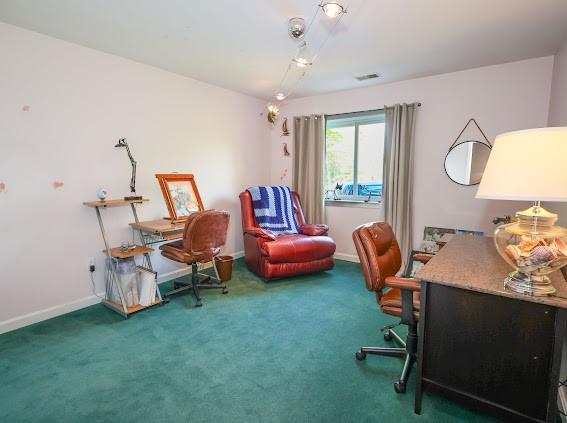 carpeted home office featuring baseboards