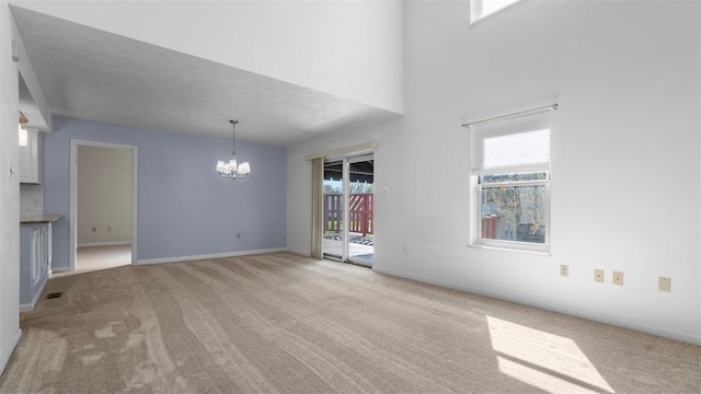 1420 Lexington Dr, Cecil, PA 15055 - unfurnished living room featuring plenty of natural light, an inviting chandelier, and light colored carpet