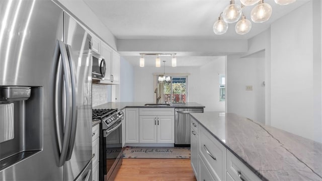 1420 Lexington Dr, Cecil, PA 15055 - kitchen with a chandelier, light wood finished floors, appliances with stainless steel finishes, and a peninsula