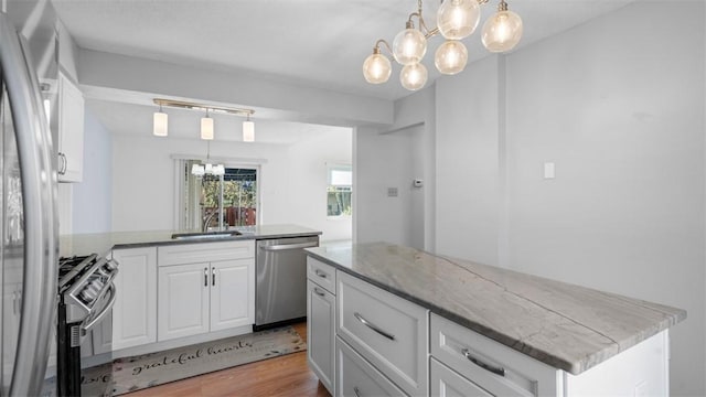 1420 Lexington Dr, Cecil, PA 15055 - kitchen with white cabinets, stainless steel appliances, a sink, light wood-type flooring, and a chandelier