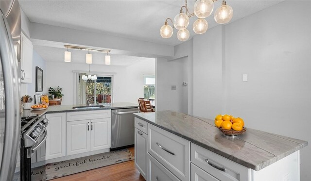 1420 Lexington Dr, Cecil, PA 15055 - kitchen with a sink, a chandelier, light wood-style flooring, appliances with stainless steel finishes, and white cabinetry