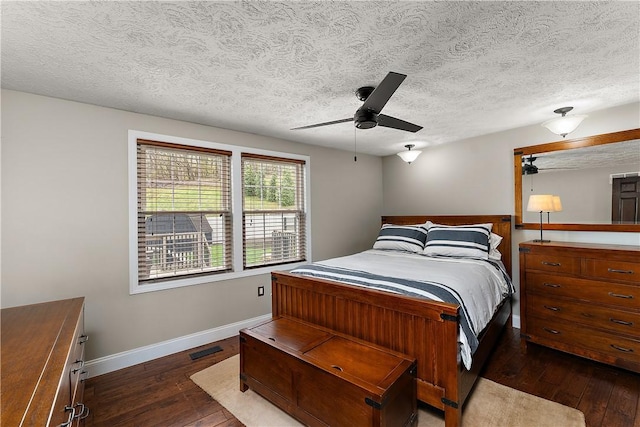 bedroom featuring baseboards, visible vents, a ceiling fan, and dark wood-style floors
