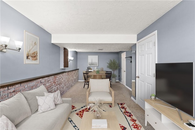 carpeted living room featuring baseboards and a textured ceiling
