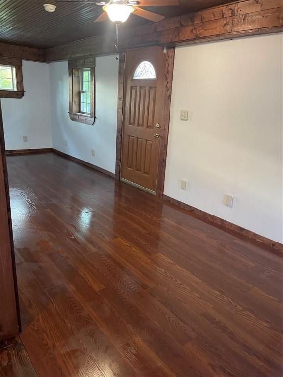 foyer featuring dark wood-type flooring, a ceiling fan, baseboards, and healthy amount of natural light