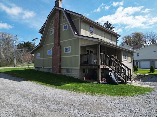 view of front facade featuring a chimney, a front lawn, and stairway