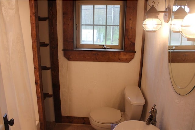bathroom featuring toilet and curtained shower