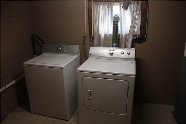 laundry area with washing machine and dryer and concrete block wall