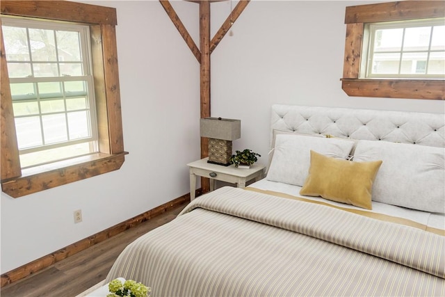 bedroom featuring multiple windows, wood finished floors, and baseboards