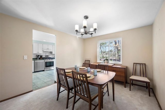 dining space featuring baseboards, light carpet, and an inviting chandelier