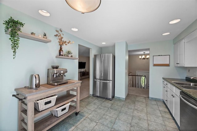 kitchen featuring white cabinets, dark countertops, appliances with stainless steel finishes, and a sink