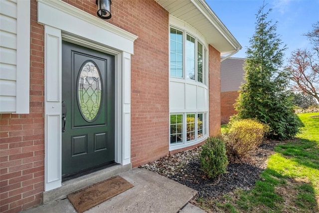 view of exterior entry featuring brick siding