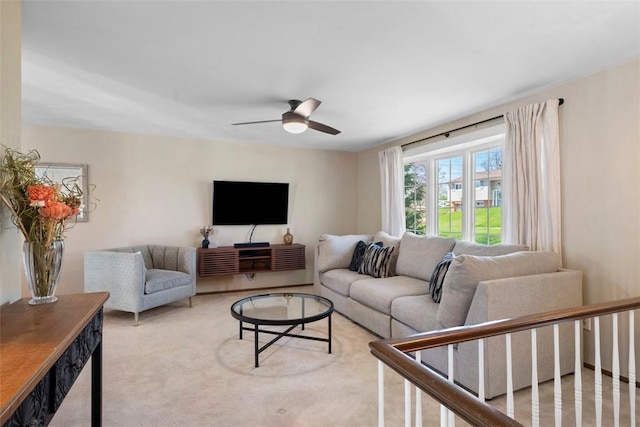 living area with a ceiling fan and light carpet