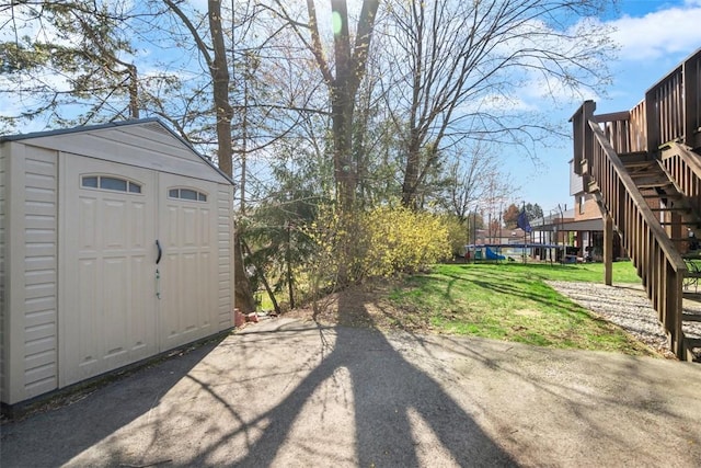 view of yard featuring a storage shed, an outbuilding, and stairs