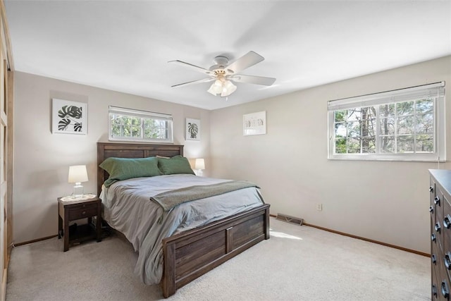 bedroom with light colored carpet, multiple windows, and visible vents