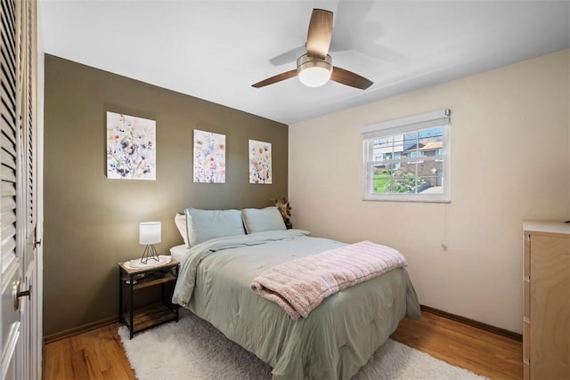 bedroom featuring wood finished floors, baseboards, and ceiling fan