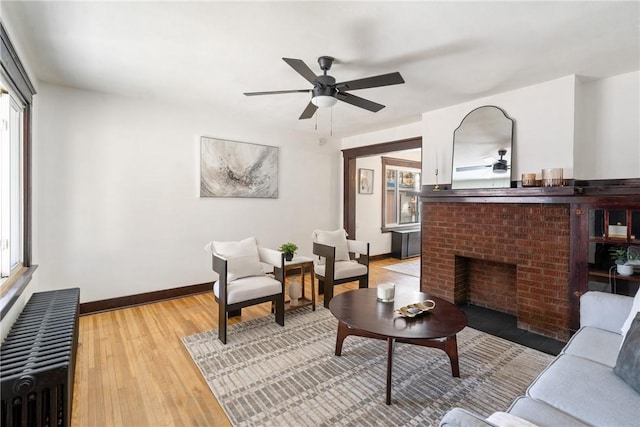 living area with ceiling fan, radiator heating unit, and plenty of natural light
