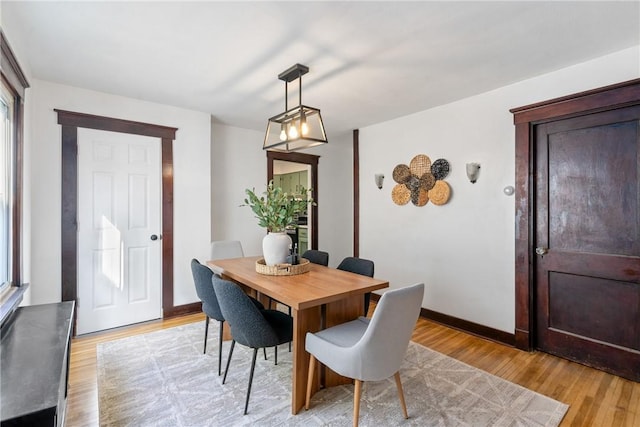 dining room featuring light wood-style floors and baseboards