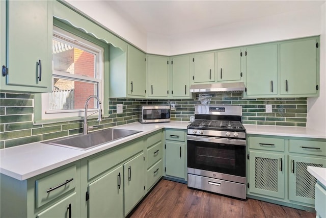 kitchen featuring under cabinet range hood, stainless steel appliances, light countertops, and a sink