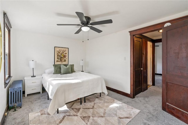 bedroom with a ceiling fan, baseboards, light colored carpet, and radiator