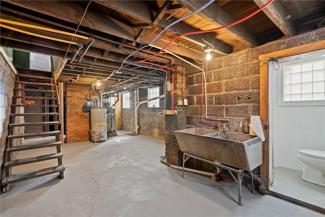 below grade area with gas water heater and a sink