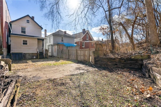 rear view of house featuring fence