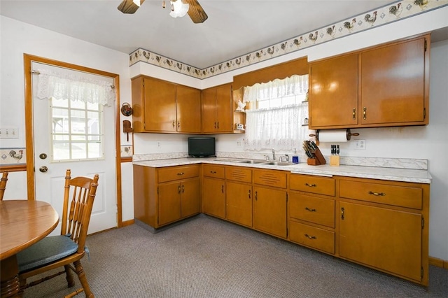 815 Franklin Ave, Connellsville, PA 15425 - kitchen with a sink, brown cabinets, ceiling fan, light countertops, and carpet flooring
