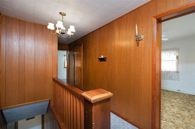 815 Franklin Ave, Connellsville, PA 15425 - hall featuring carpet floors, wooden walls, and an inviting chandelier