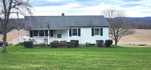 back of house featuring a yard and a chimney