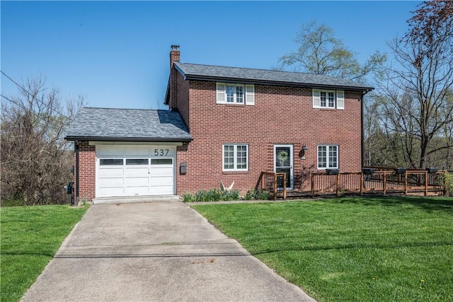 colonial inspired home with a chimney, brick siding, a garage, driveway, and a front yard