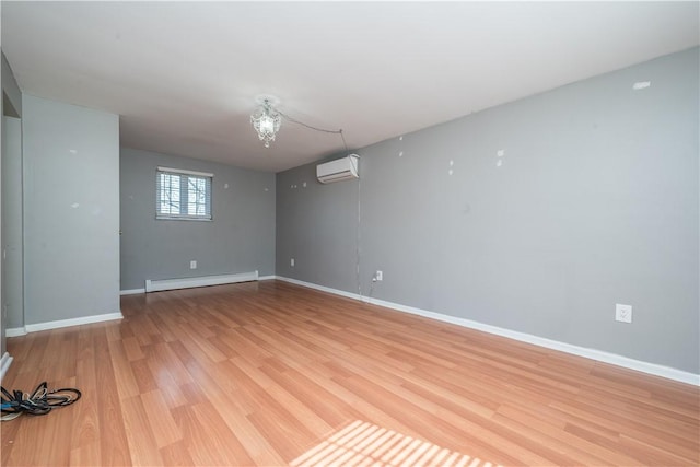 unfurnished room with a baseboard radiator, light wood-style floors, a wall unit AC, and baseboards