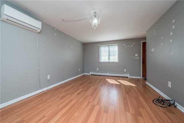 spare room with a baseboard radiator, light wood-style flooring, an AC wall unit, and baseboards