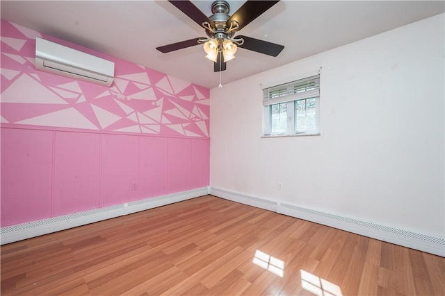 empty room featuring light wood-style floors, ceiling fan, baseboards, an AC wall unit, and a decorative wall