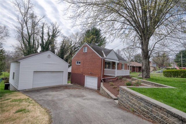 3181 Coulterville Rd, North Huntingdon, PA 15131 - view of side of property featuring a detached garage, an outdoor structure, a yard, brick siding, and covered porch